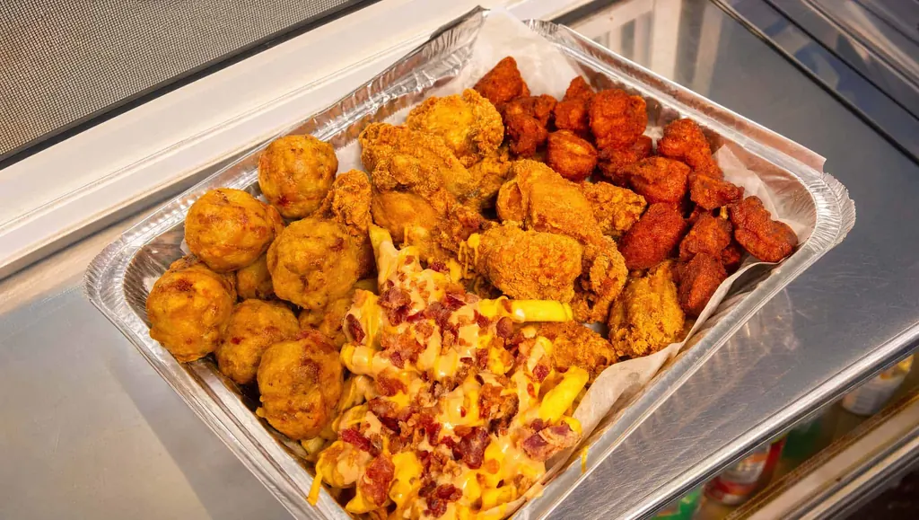 Large party tray loaded with bolitas de mofongo, papas con queso y bacon, chicharrones de pollo and alitas