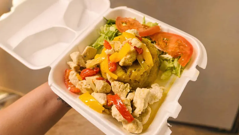 Mofongo topped with seasoned pollo, sweet peppers, lettuce and tomato